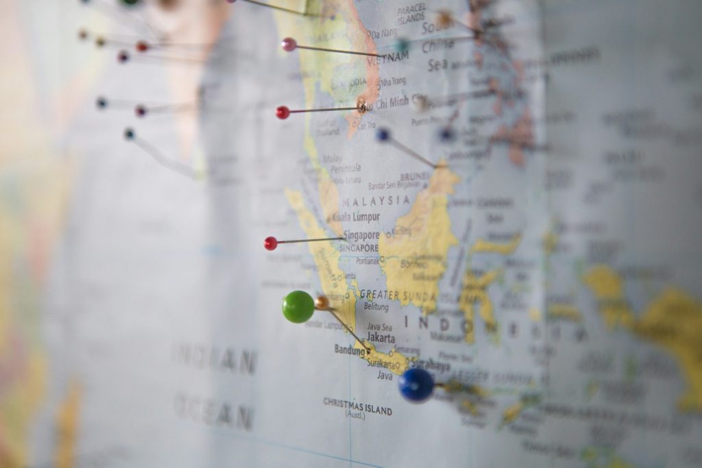 World map with location pins, representing a comparison of DeepSeek and Claude for translation
