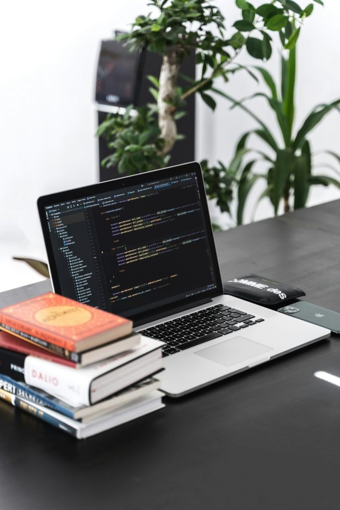 MacBook Pro on a wooden desk, representing a hybrid AI and human translation workflow